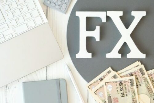 デスクの上のパソコンとお金とＦＸのイメージ