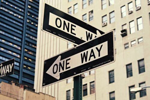 英語の「ONE WAY」の道路標識がある風景