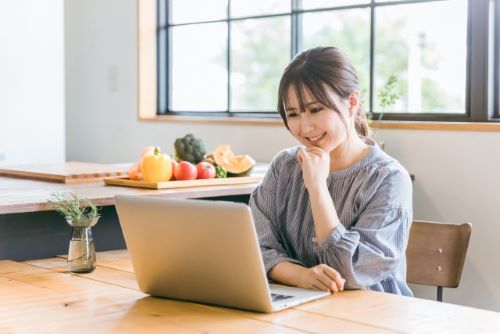 ウッドデスクでテレワークをする女性